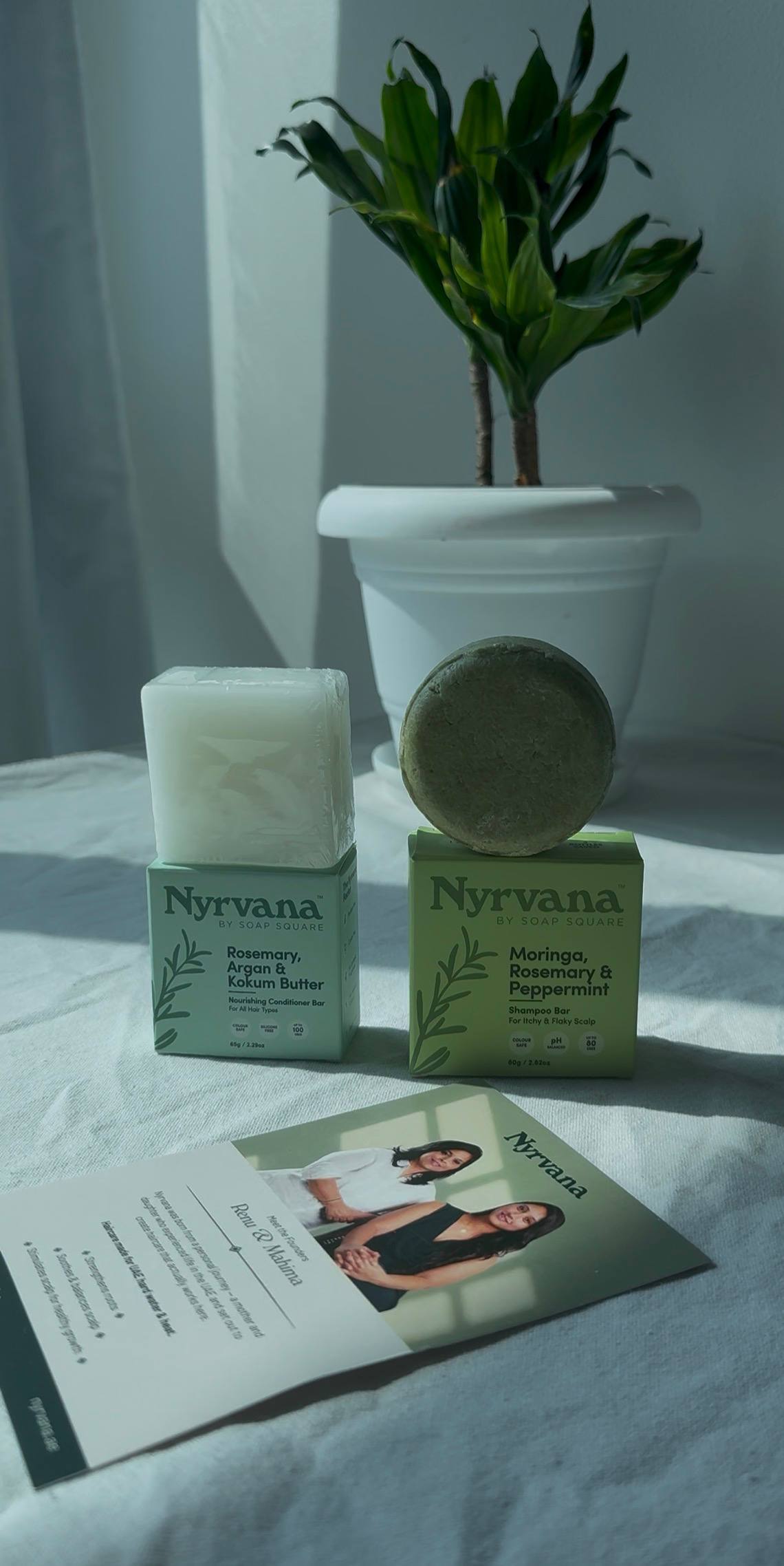 Nyrvana shampoo and conditioner bars on a bathroom shelf